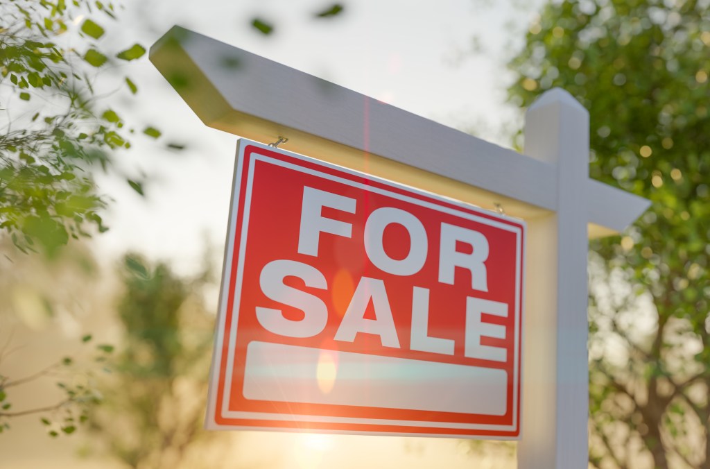 For Sale Real Estate Sign In Front Of The Property.