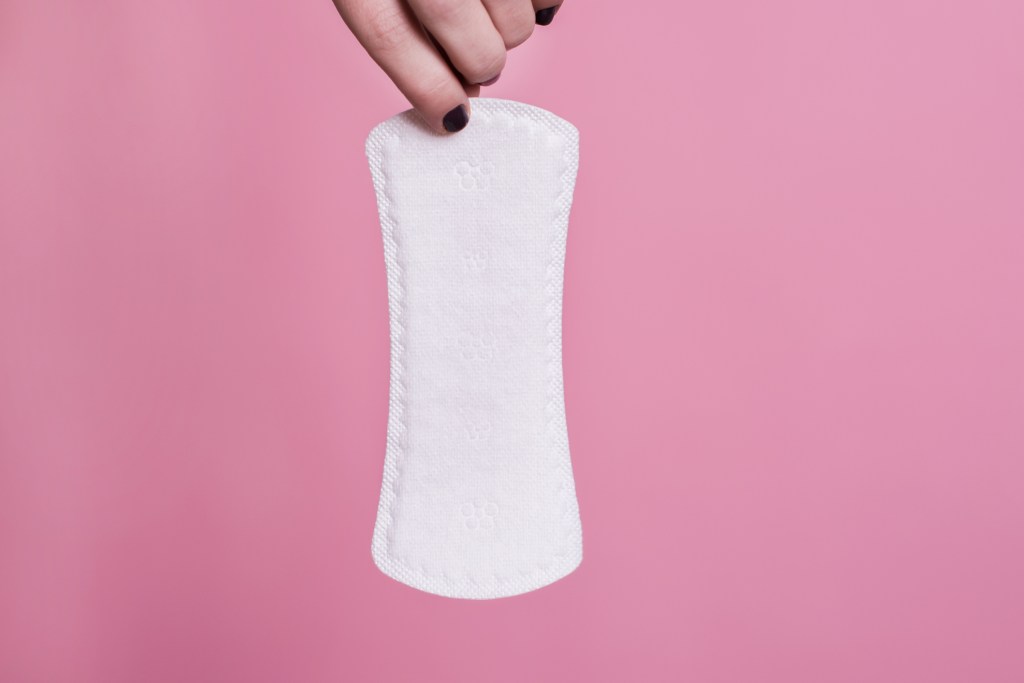 Woman holding a white sanitary napkin